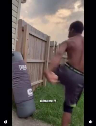 Kicking a boxing bag leaning on a wall