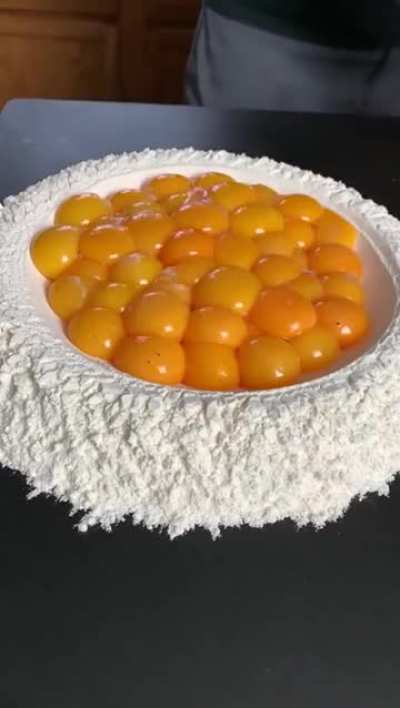 The way the chicken eggs and ostrich egg is poured over flour