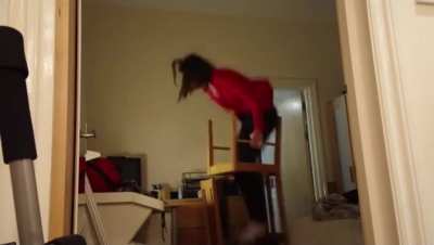 Standing on two chairs on top eachother to change the lightbulb
