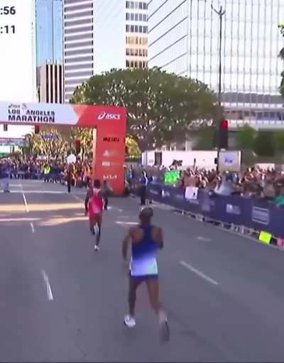 BY A WHISKER! American Nathan Martin explodes past Kenyan Michael Kimani Kamau in the final stride to steal the LA Marathon men’s pro crown in 2:11:16.50 — winning by an insane 0.01 seconds! Pure chaos at the line!