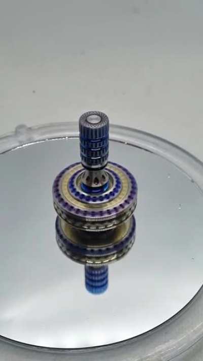 precision spinning top doing its thing! The contact point is a 1/8" corrundum Ruby. spin time is around 12 minutes. This one's made from bronze and titanium.