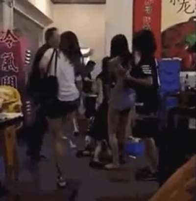 A pack of girls bullying somebody on the ground