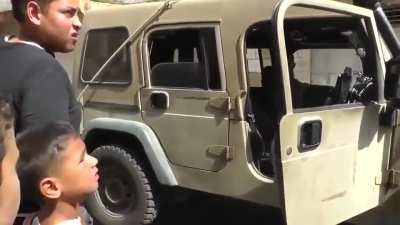 Heavily armed Israeli soldiers arrest a Palestinian child