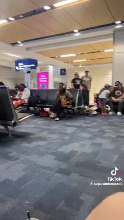 Lady irritates airport by singing at the top of her lungs.