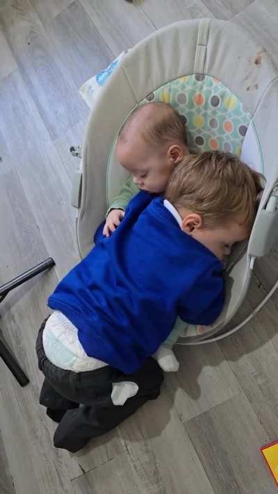 A brother and sister fall asleep hugging eachother