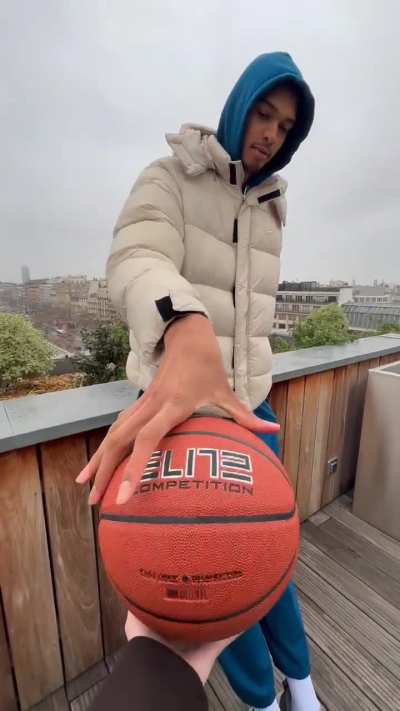 7ft4 Victor Wembenyama palms a basketball with 2 fingers.