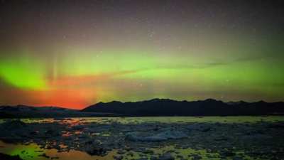 Solar storm above active volcanic eruption in Iceland