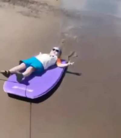 Cool baby being pulled on a bodyboard