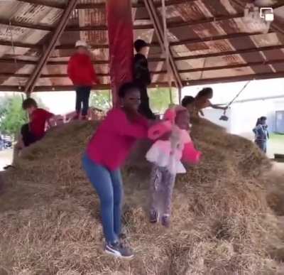 Lady tries to teach kid how to swing on a rope....