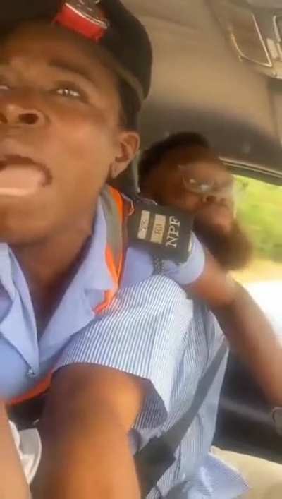 A female police officer (traffic warden) in Nigeria cries for help after jumping into a car for alleged traffic law violation and the driver refuses to drive to the police station.