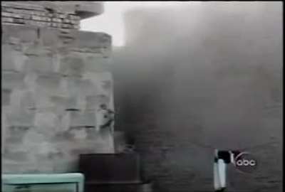 [Iraq] After an Iraqi insurgent falls in between two buildings, a Marine throws a hand grenade in the gap, then uses his rifle to kill him. Fallujah, Iraq. November 2004. 3/5th Marines.