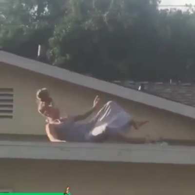 Drunk white lady standing on her roof, bangs beer can on her head, slips on a skateboard while being flipped off by a 5 year old child standing near a care free pig