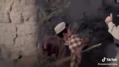 Marines walk past afghani child