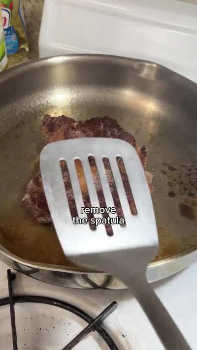 Cooking a ribeye steak in a stainless steel pan