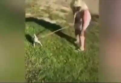 Woman getting an imaginary bite from apparently a doberman.