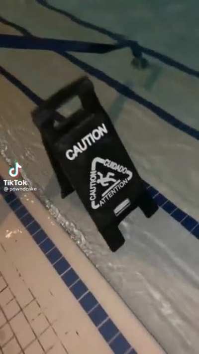 Wet floor sign beside a pool......