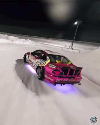 Straight out of a video game! Professional drifter on a snow covered track shot with FPV drone