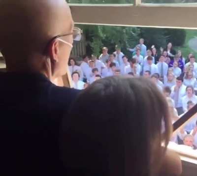 Students gather outside the home of their cancer-stricken teacher to sing for him.