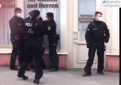 An elderly German woman walking her dog is stopped and questioned by police per COVID regulations. The woman challenges the ethics of these measures, calling them crazy, until officers gang up and arrest her. Is our "safety" worth the collapse of a free a