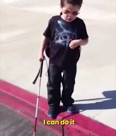 Blind kid experience his first curb by himself while his parents encouraged him.