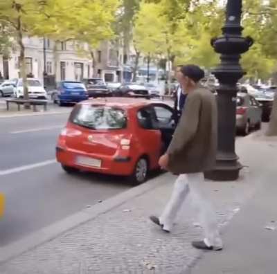 Homeless man laughs at car