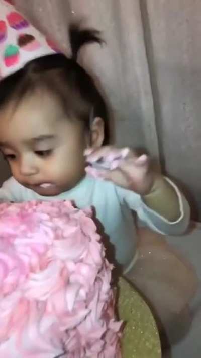Pushing baby's face into birthday cake