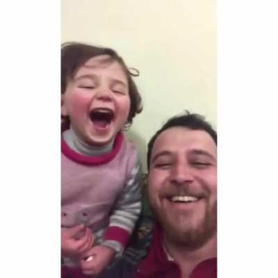 To distract his 4-year old daughter, her father has made up a game. Each time a bomb drops in Idlib Syria, they laugh, so she doesn&rsquo;t get scared.