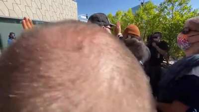 Man with Dave sign clashes with protesters at the Netflix Trans solidarity walkout.