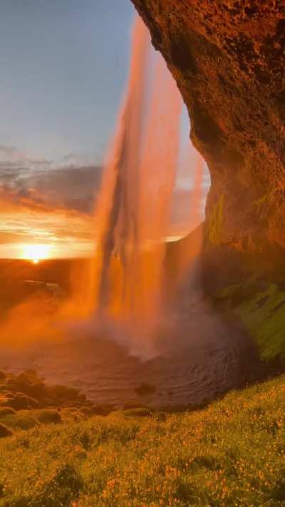 Seljalandsfoss is one of Iceland's most iconic waterfalls situated along the south coast, is the result of the Seljalands&aacute; River cascading dramatically over a cliff's edge.What sets it apart from other waterfalls is the unique opportunity to stand directl