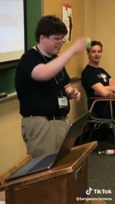 Guys celebrates after fellow classmate solves a rubik's cube