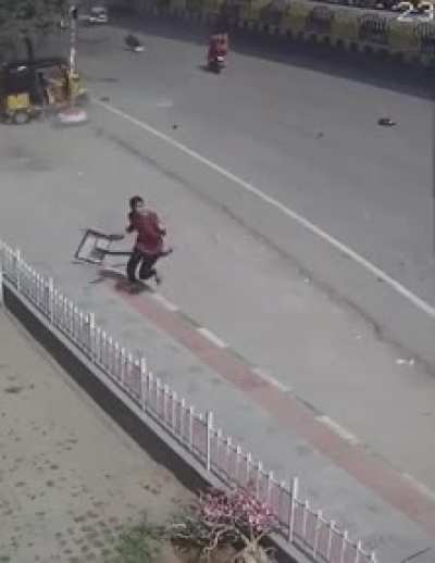 Woman avoids getting hit by a sign because of a car falling from the sky