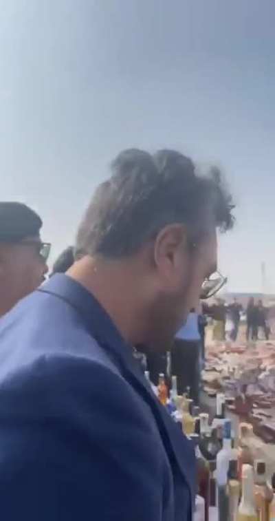 Based Pakistanis destroying all confiscated liquor bottles.