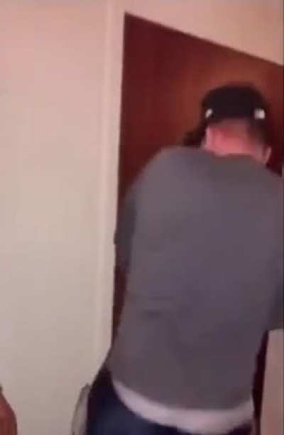 Trying to hide between the doors separating two hotel rooms