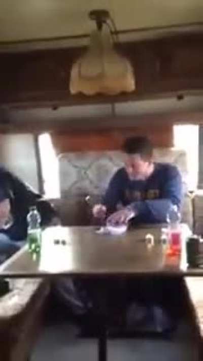 Two people trying to eat Surstr&ouml;mming (fermented fish!), A typical swedish dish. It is said that the smell is so strong that the recommendation is to open the can outside the house, inside a bucket full of water.