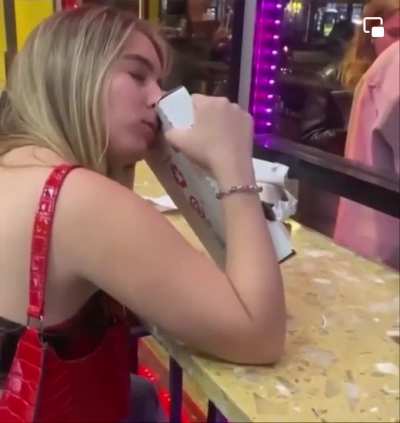 Woman calmly eats a pizza box.