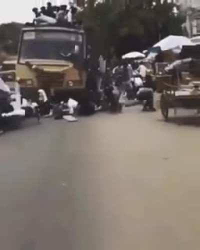 Motorbike rider checking an overloaded bus not realising inertia exists.