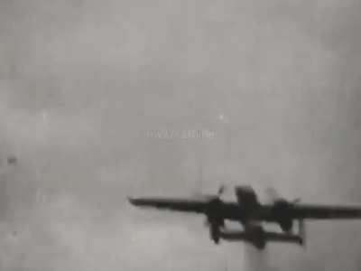 B-25 Mitchell bomber with "invasion stripe" markings and port undercarriage lowered trailing smoke while under fire from a Luftwaffe fighter in 1944