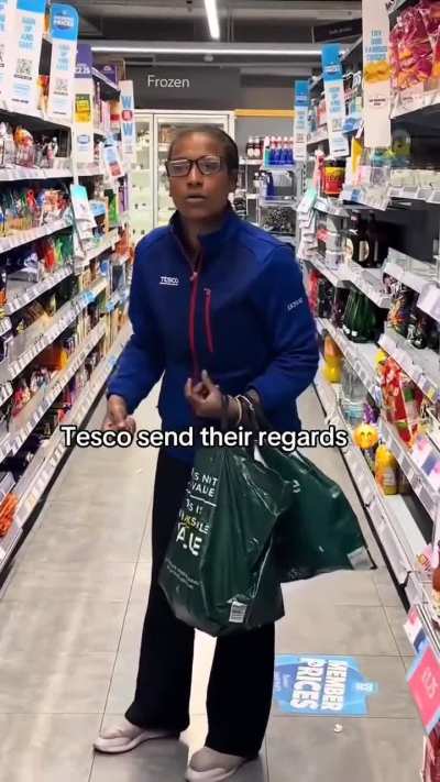A woman wearing a Tesco jacket stealing from a Co-op store.
