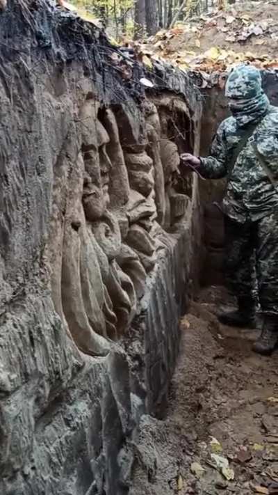 Ukrainian soldier carves faces in the trench 