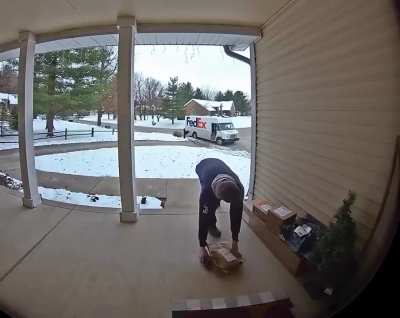 FedEx driver takes a moment to organize packages left scattered on the porch
