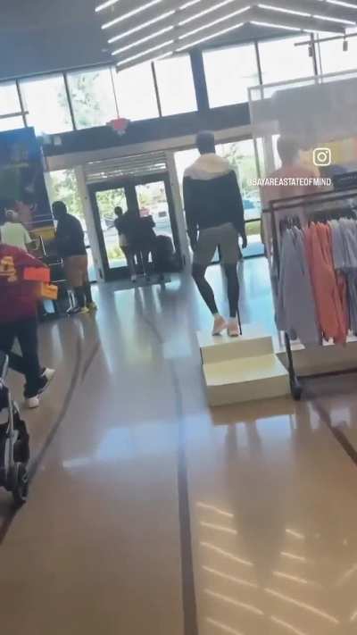 A group of gentlemen fill up garbage bags of stolen merchandise at a Nike store in California