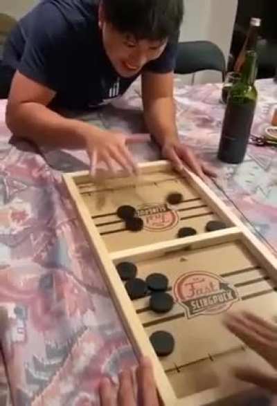 Players race each other to clear the pucks from their side of the board