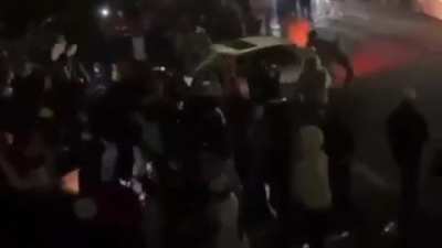 Car accidently hits crowd of people while doing donuts, crowd tries to pull him out of car, fireworks, ground catches fire, mayhem.