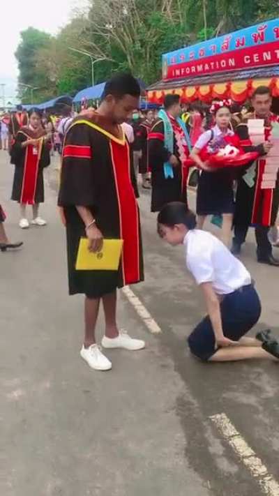 Thai woman kneels &amp;amp; bows down to brother who gave up his education so she can graduate