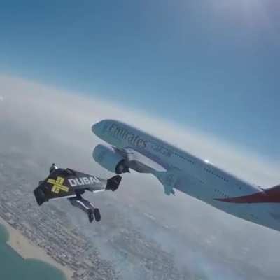 Man with a jetpack, flying next to a plane