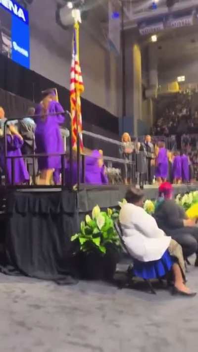 High schooler at South Plantation High School, Florida does a backflip and accidentally kicks the girl behind him while accepting his diploma