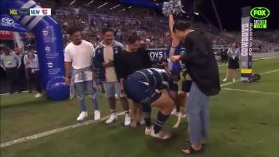 Jason Taumalolo cuddles his dog before his 200th game