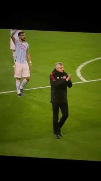 Bruno defending Ole from the away fans and pointing at the players instead
