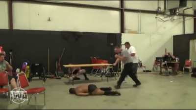 Wrestler goes for elbow drop from halfway up a wall and misses his opponent and crashes to the floor