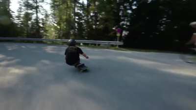 Long boarder going down a mountain road at over 60 mph